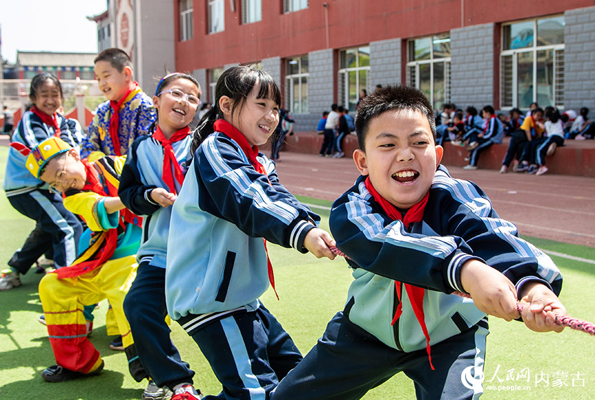 5月8日，呼和浩特市玉泉区南柴火市街小学学生在参加拔河比赛。丁根厚摄