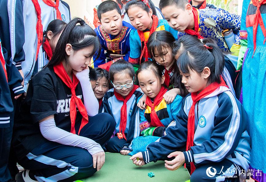 5月8日，呼和浩特市玉泉区南柴火市街小学学生在进行“玩羊拐”比赛。丁根厚摄