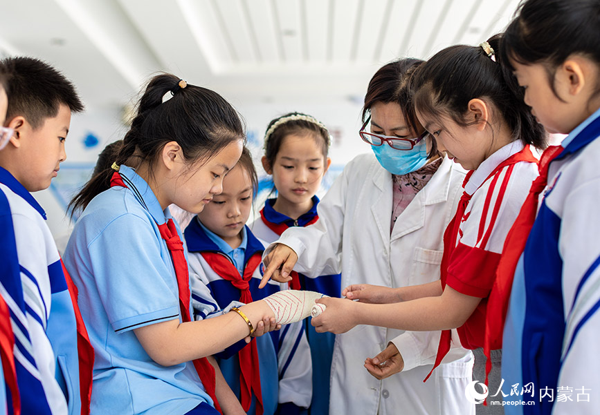 5月11日，呼和浩特市玉泉区通顺街小学学生在学习应急救护包扎。丁根厚摄