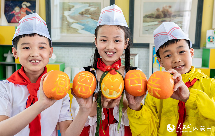 5月12日，呼和浩特市玉泉区五塔寺东街小学学生在展示以“感恩母亲”为主题的果蔬作品。丁根厚摄