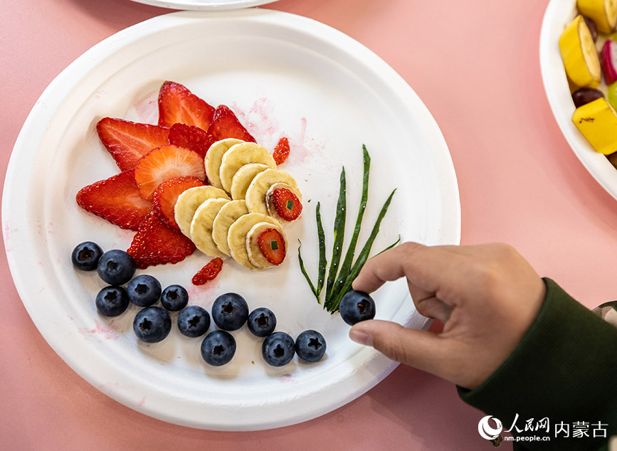 5月12日，呼和浩特市玉泉区五塔寺东街小学学生在制作水果拼盘。丁根厚摄