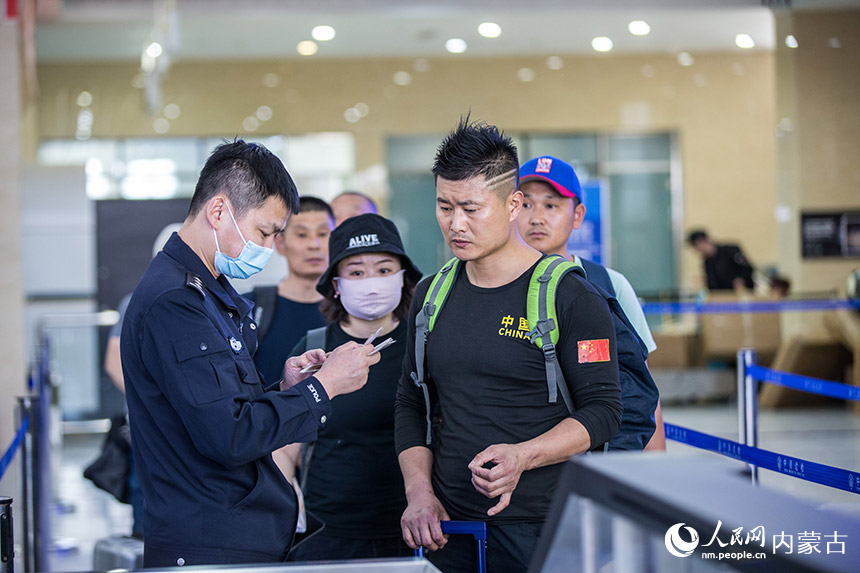 二連出入境邊防檢查站執勤民警為旅客提供通關咨詢引導。胡富國攝