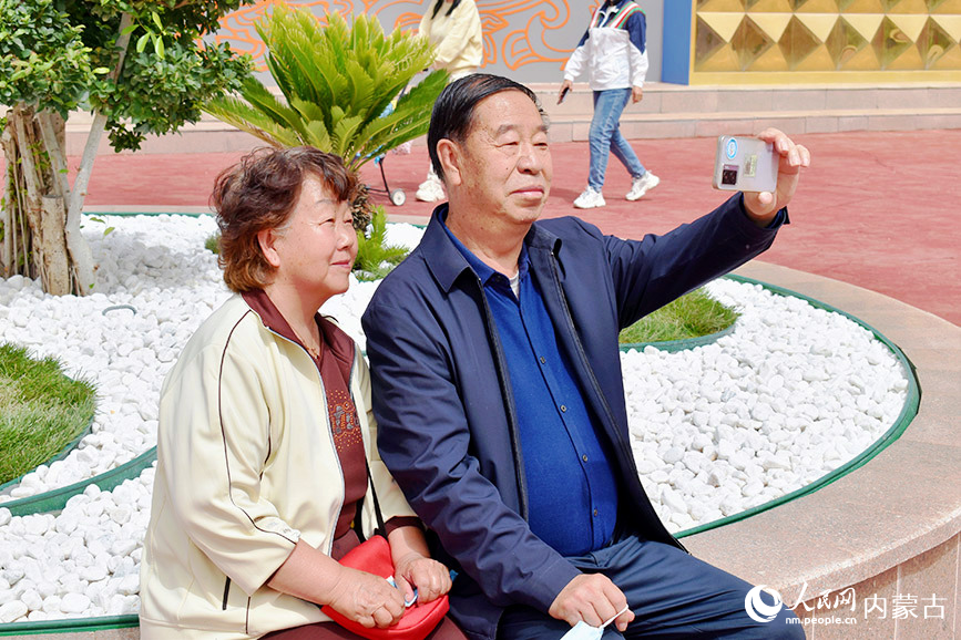 一对夫妻正在婚礼墙前合影。实习生 李星雨摄