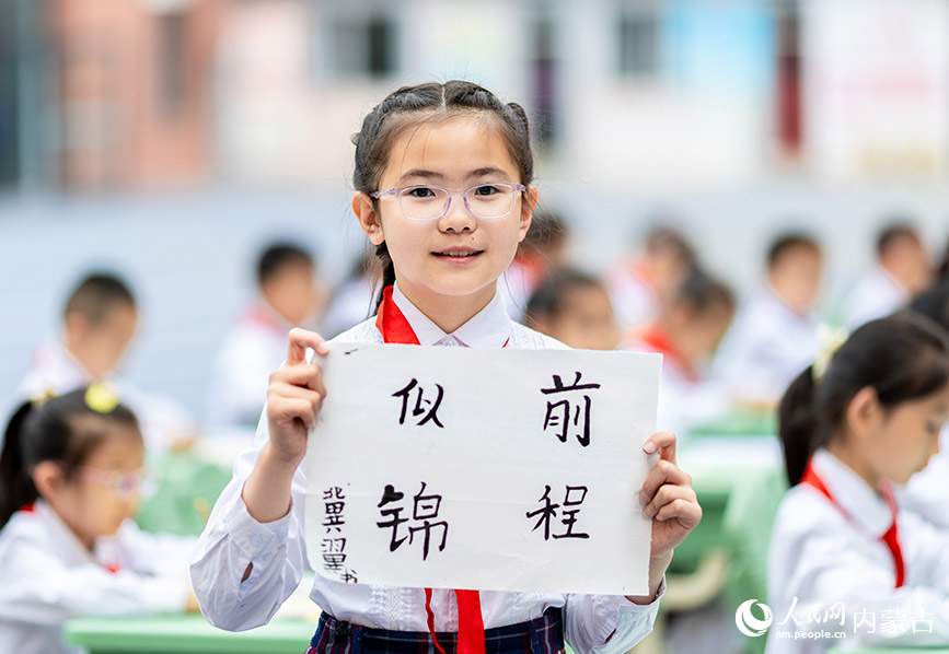 5月31日，内蒙古呼和浩特市玉泉区恒昌店巷小学学生在展示刚刚书写的书法作品。丁根厚摄