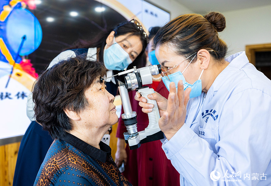 6月2日，眼科医生在内蒙古呼和浩特市玉泉区老年大学为老年人做眼科检查。丁根厚摄