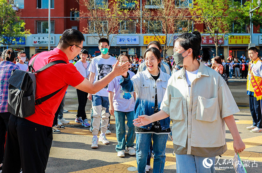 内蒙古呼和浩特市第六中学考点，考生进入考场前与老师击掌。丁根厚摄
