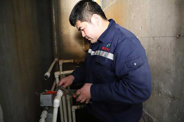 工作人员正在为居民更换水表。赵冬霞摄
