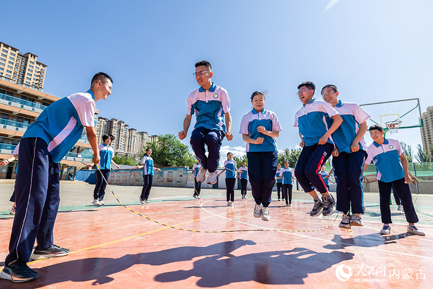 6月13日，呼和浩特市第二十七中学初三年级的学生在体育课上进行跳绳游戏。丁根厚摄