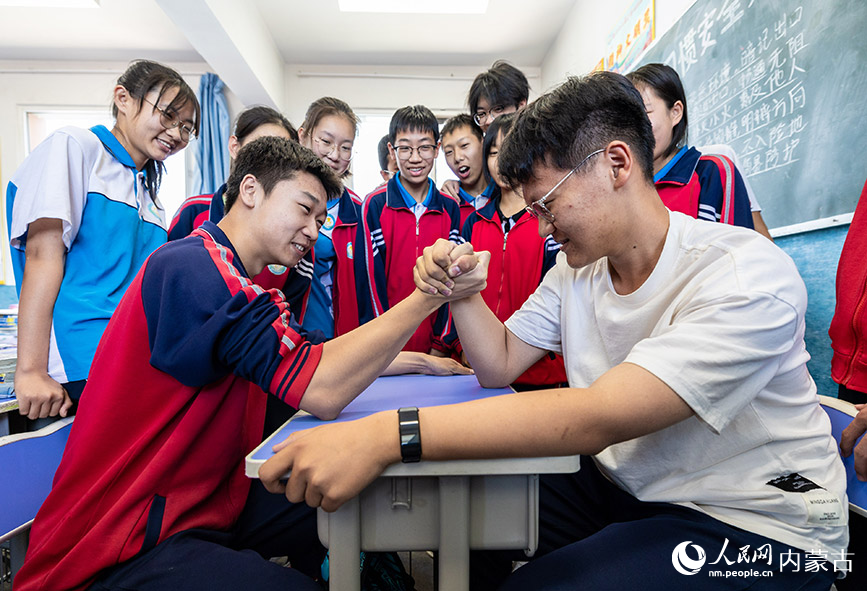 6月13日，呼和浩特市第二十七中学初三年级学生在课间进行掰手腕比赛。丁根厚摄