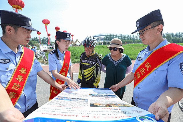民警为现场群众发放宣传手册并讲解毒品危害及涉毒法律法规。