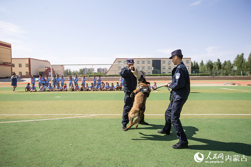 二连出入境边防检查站移民管理警察为学生们进行警犬战术表演。郭鹏杰摄