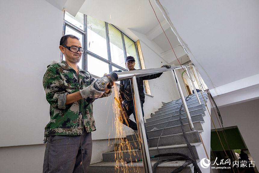 工人在呼和浩特市玉泉区云中路幼儿园建设项目现场进行楼道护栏安装施工。丁根厚摄