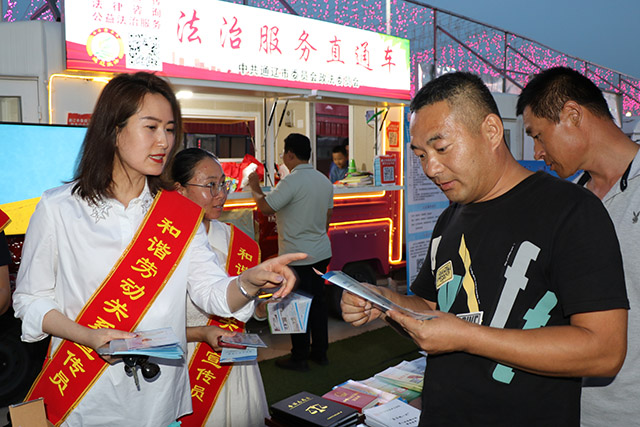 ”普法小摊“工作人员向市民发放宣传册。包乌兰摄