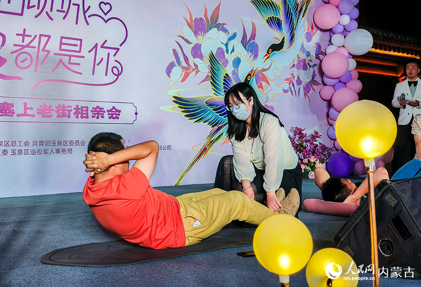 青年男女在呼和浩特市玉泉区第二届塞上老街相亲会上玩互动游戏。丁根厚摄