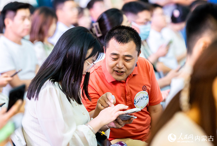 一对单身男女在呼和浩特市玉泉区第二届塞上老街相亲会上相互交流。丁根厚摄