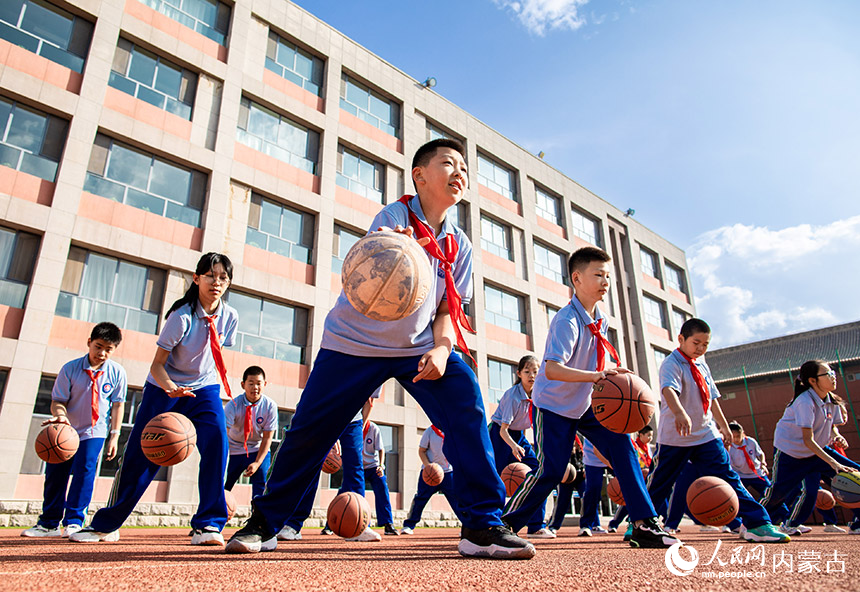 呼和浩特市玉泉区通顺街小学学生在体育课上练习篮球。丁根厚摄