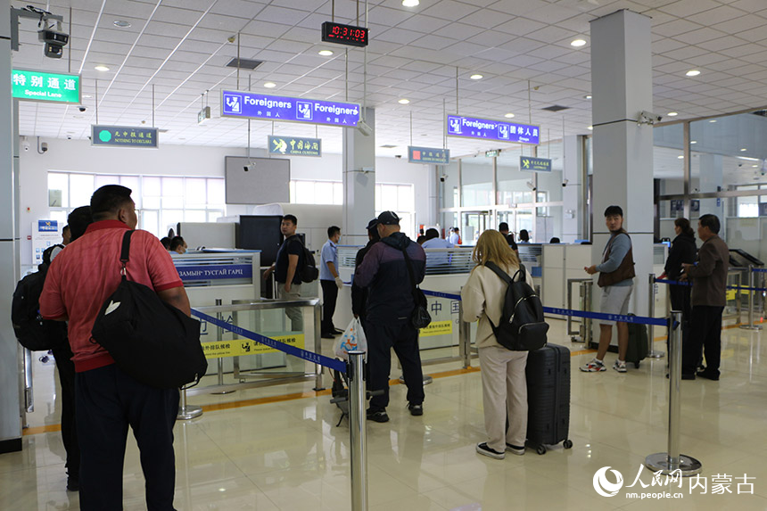 乘坐中蒙铁路国际旅客列车的旅客在联检大厅排队候检。刘剑辉摄