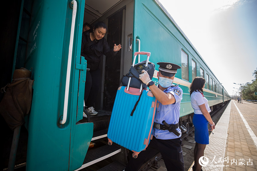 二连出入境边防检查站执勤民警帮助旅客提拿行李。郭鹏杰摄