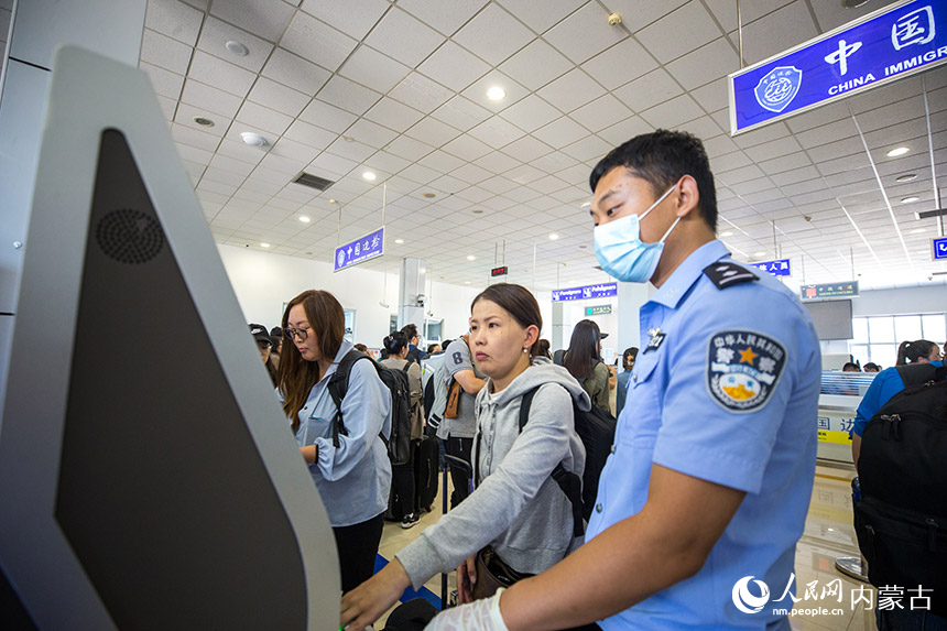 二連出入境邊防檢查站執勤民警協助旅客辦理通關手續。郭鵬杰攝