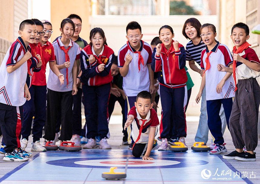 呼和浩特市玉泉区恒昌店巷小学学生在玩“旱地冰壶”游戏。丁根厚摄