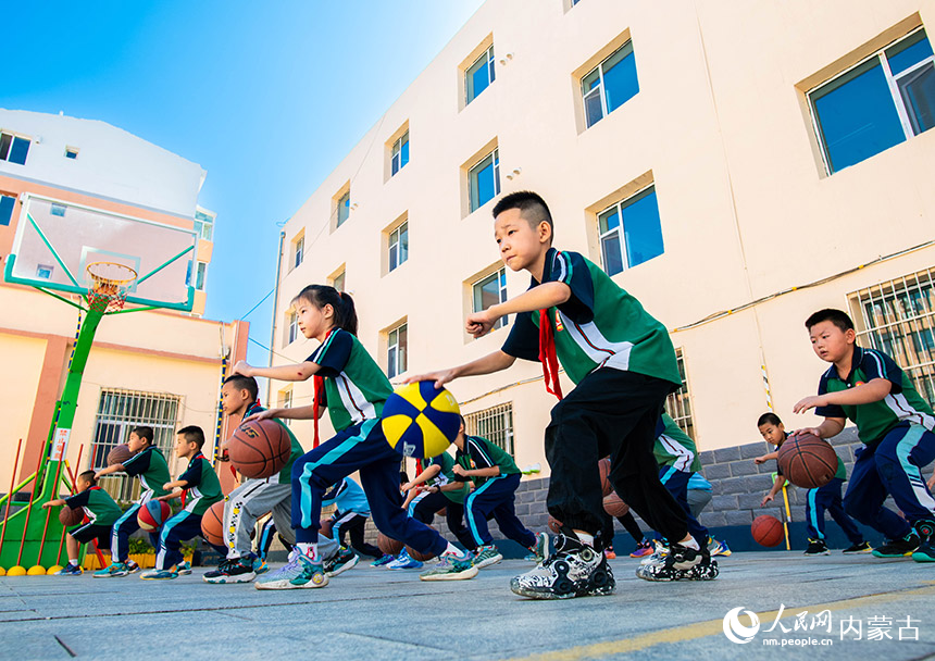 呼和浩特市玉泉区恒昌店巷小学学生在练习篮球基本动作。丁根厚摄
