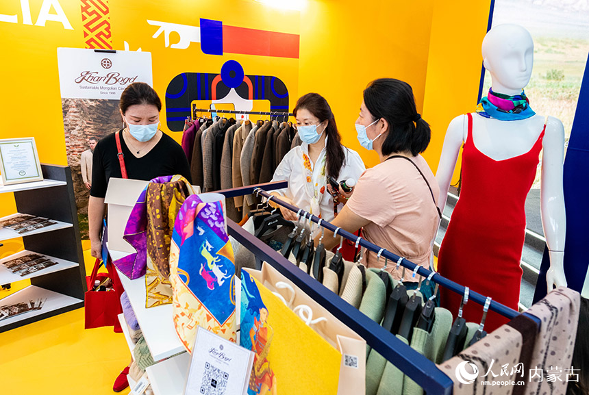 观众在第四届中国—蒙古国博览会上选购蒙古国商品。丁根厚摄