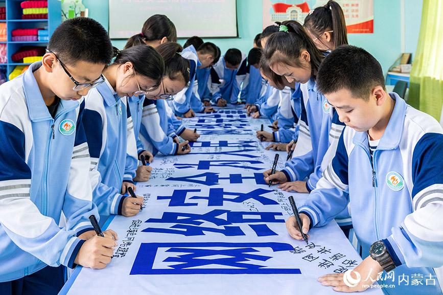 9月11日，呼和浩特市第二十七中学学生在“网络安全为人民 网络安全靠人民”宣传条幅上签名。丁根厚摄