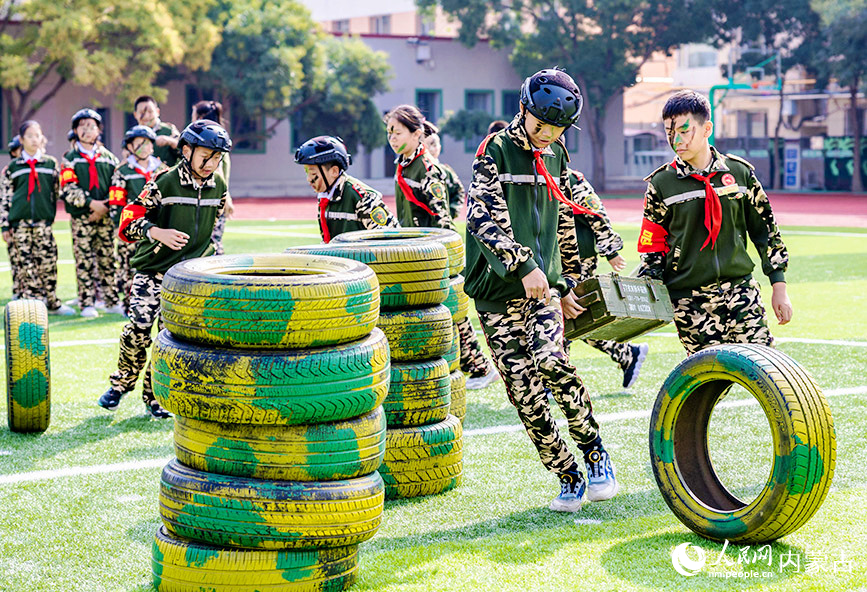 9月14日，呼和浩特市玉泉區五塔寺東街小學少年軍校學員在進行“運送彈藥箱”比賽。丁根厚攝