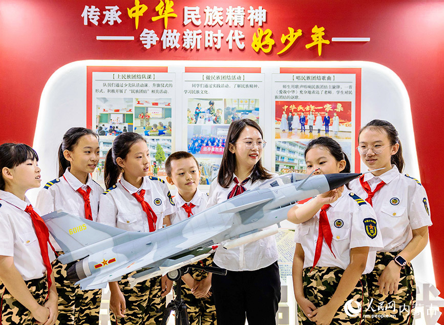 9月14日，呼和浩特市玉泉區五塔寺東街小學少年軍校老師通過模型為小學員們科普軍事裝備知識。丁根厚攝