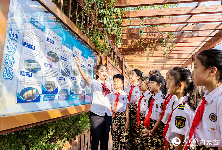 9月14日，呼和浩特市玉泉區五塔寺東街小學少年軍校老師為小學員們講解國防科技成就。丁根厚攝