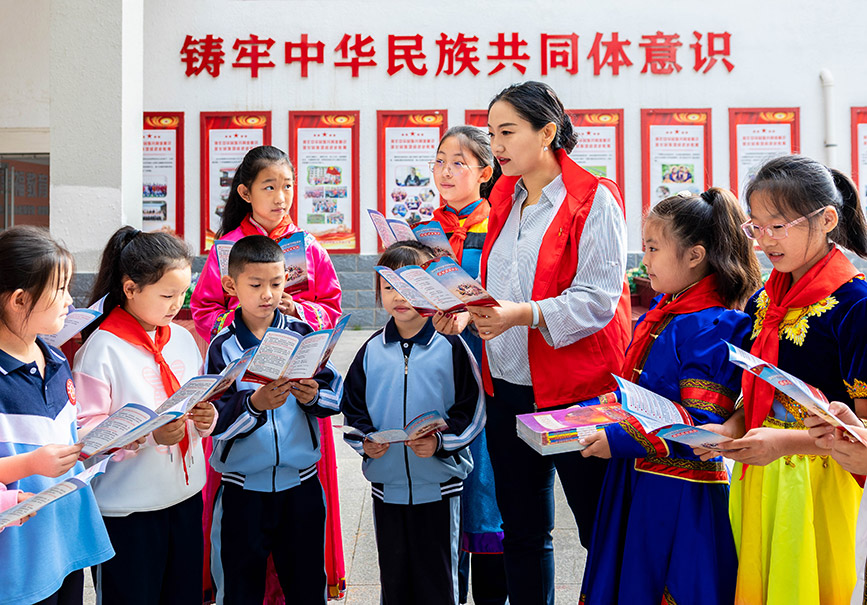 9月25日，內蒙古自治區黨委統戰部綜合保障中心黨支部的志願者在為孩子們發放民族團結知識宣傳手冊。丁根厚攝