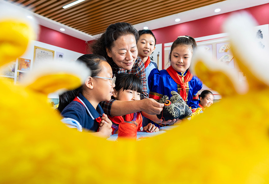 9月25日，非遺傳承人董存娥在為呼和浩特市玉泉區南柴火市街小學學生傳授布老虎的制作技藝。丁根厚攝