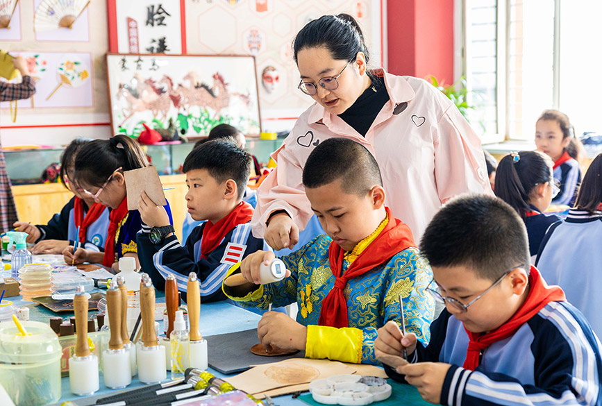 9月25日，呼和浩特市玉泉區南柴火市街小學學生在老師的指導下，學習制作蒙古族皮雕畫。丁根厚攝