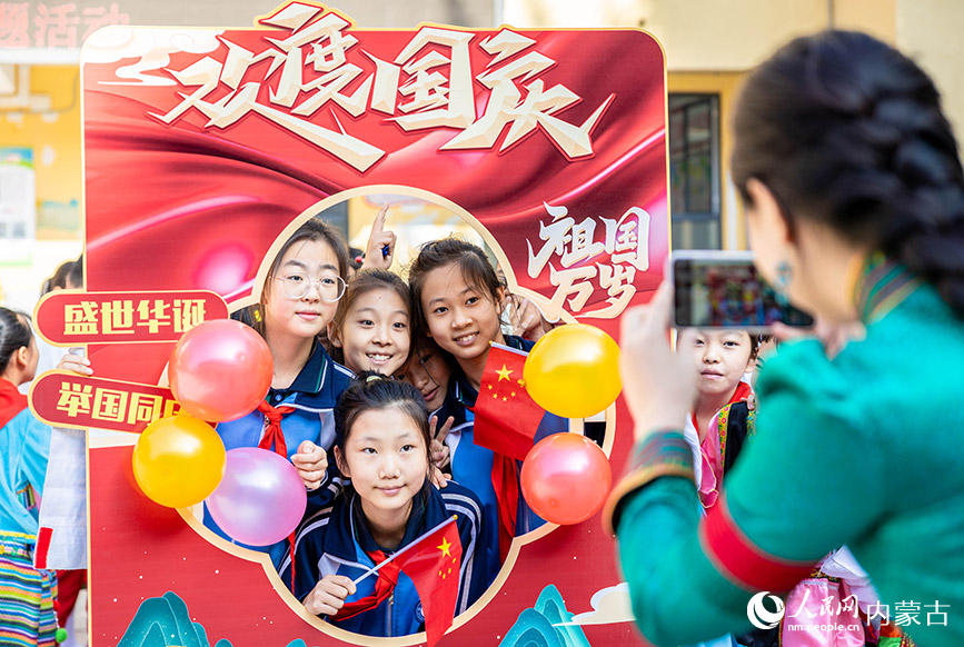 9月26日，呼和浩特市玉泉區清泉街小學師生在“童心頌祖國 歡歌迎國慶”主題活動現場打卡拍照。丁根厚攝