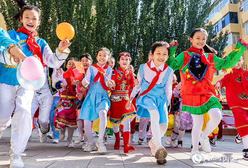 9月26日，呼和浩特市玉泉區清泉街小學學生在“童心頌祖國 歡歌迎國慶”主題活動現場歡呼。丁根厚攝