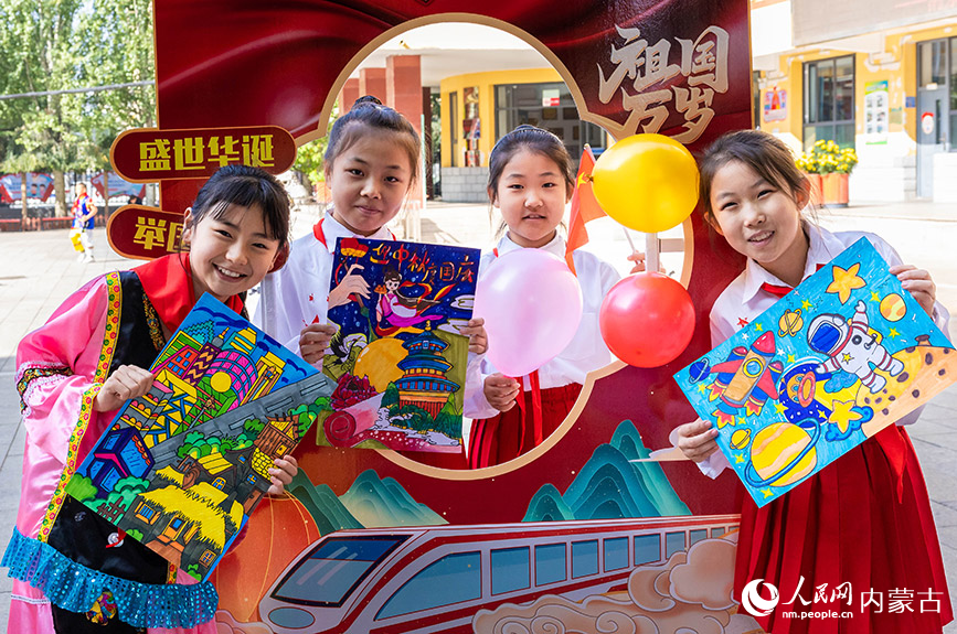 9月26日，呼和浩特市玉泉區清泉街小學學生展示繪制的迎國慶主題繪畫。丁根厚攝