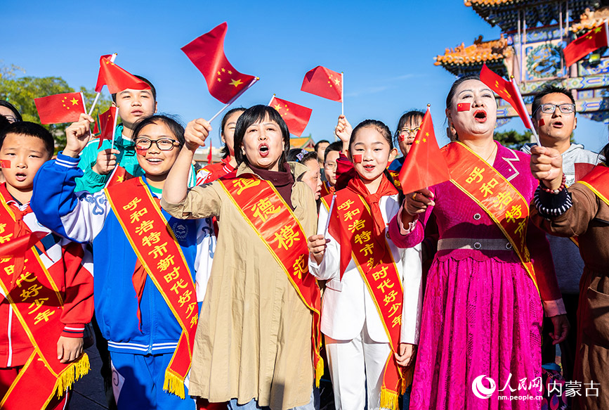 10月1日，道德模范、新时代好少年和最美志愿者等代表在呼和浩特市玉泉区塞上老街文化旅游休闲街区同唱歌曲《歌唱祖国》。丁根厚摄