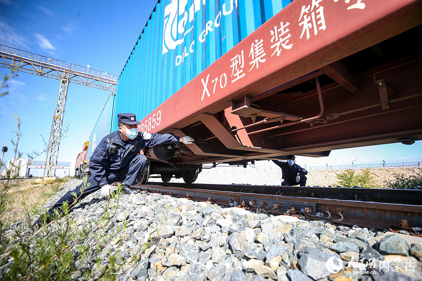 二連出入境邊防檢查站執勤民警對中歐班列進行車體檢查。郭鵬杰攝