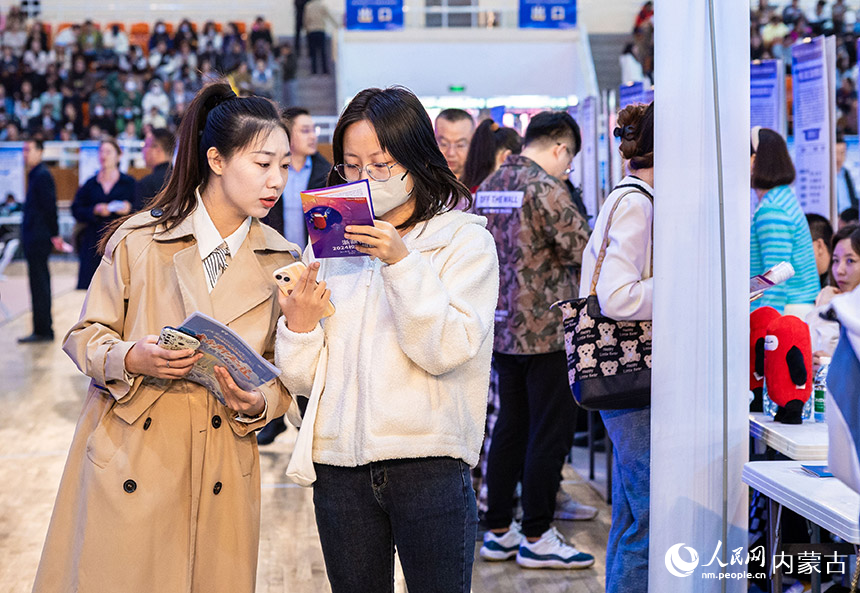 求职者在招聘活动现场了解招聘信息。丁根厚摄