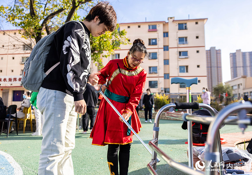 10月18日，内蒙古建筑职业技术学院现代服务与管理学院的志愿者在为老人展示适老化产品。丁根厚摄