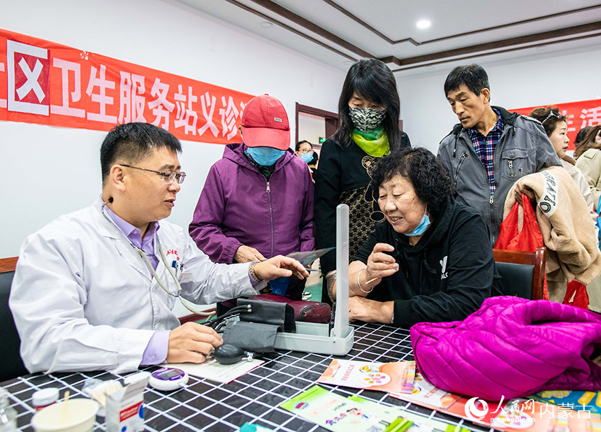 医护志愿者在呼和浩特市玉泉区“我们的节日·重阳节”活动现场为康居社区老人义诊。丁根厚摄