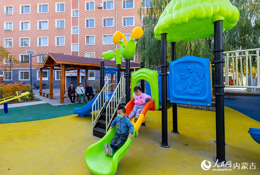 小朋友在呼和浩特市玉泉区滨江花园小区改造后的儿童乐园玩耍。丁根厚摄