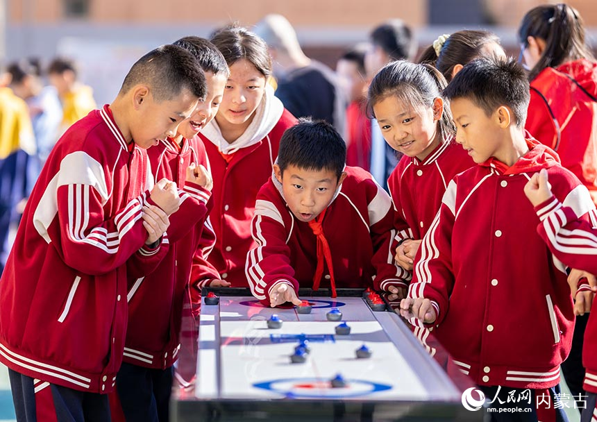 呼和浩特市玉泉区恒昌店巷小学学生在参加“桌面冰壶”游戏。丁根厚摄
