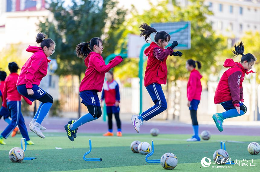 呼和浩特市玉泉区石东路小学学生在绿茵场训练腿部力量。丁根厚摄