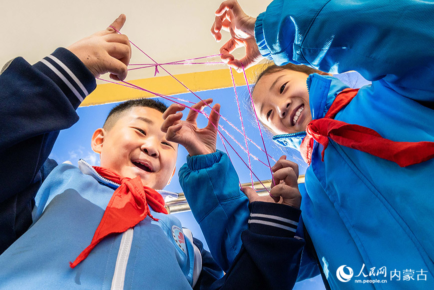 11月27日，呼和浩特市玉泉区清泉街小学的学生利用课间时间玩翻花绳。丁根厚摄