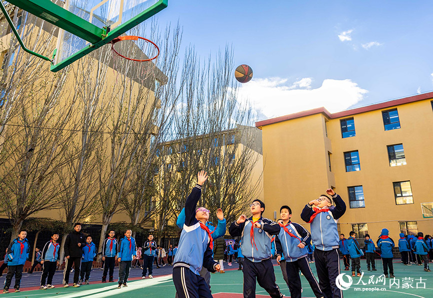 11月27日，呼和浩特市玉泉区清泉街小学的学生利用课间时间玩篮球。丁根厚摄