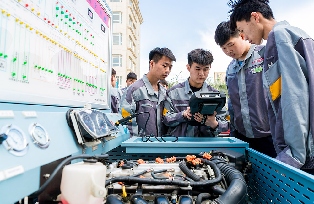 内蒙古呼和浩特市汽车工程职业技术学校学生在展示汽车维修技能。