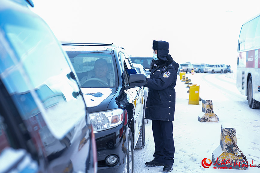 11月28日，二连出入境边防检查站执勤民警顶风冒雪快速验放通关车辆。杨金烨摄