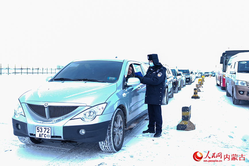 11月28日，二连出入境边防检查站执勤民警顶风冒雪快速验放通关车辆。杨金烨摄