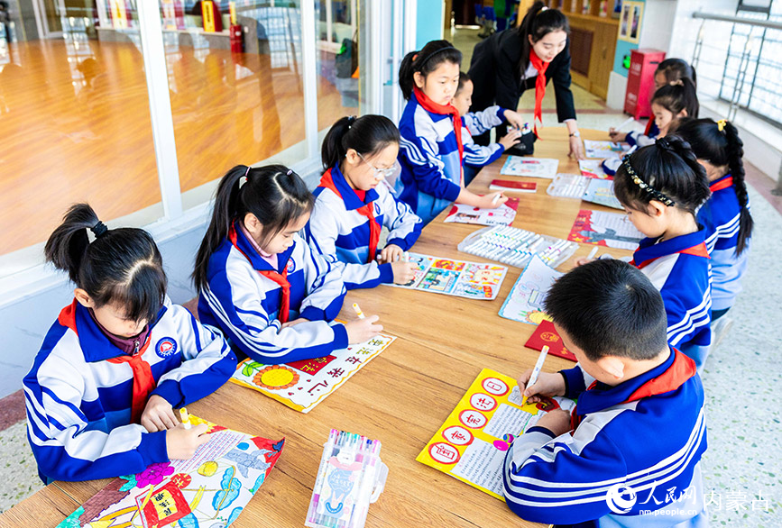 12月4日，呼和浩特市玉泉区通顺街小学学生在绘制以国家宪法日为主题的手抄报。丁根厚摄